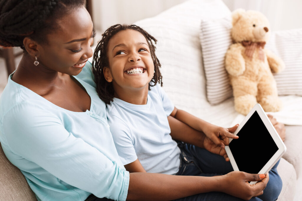 Black Mother And Daughter Using Digital Tablet, Spending Time Together At Home