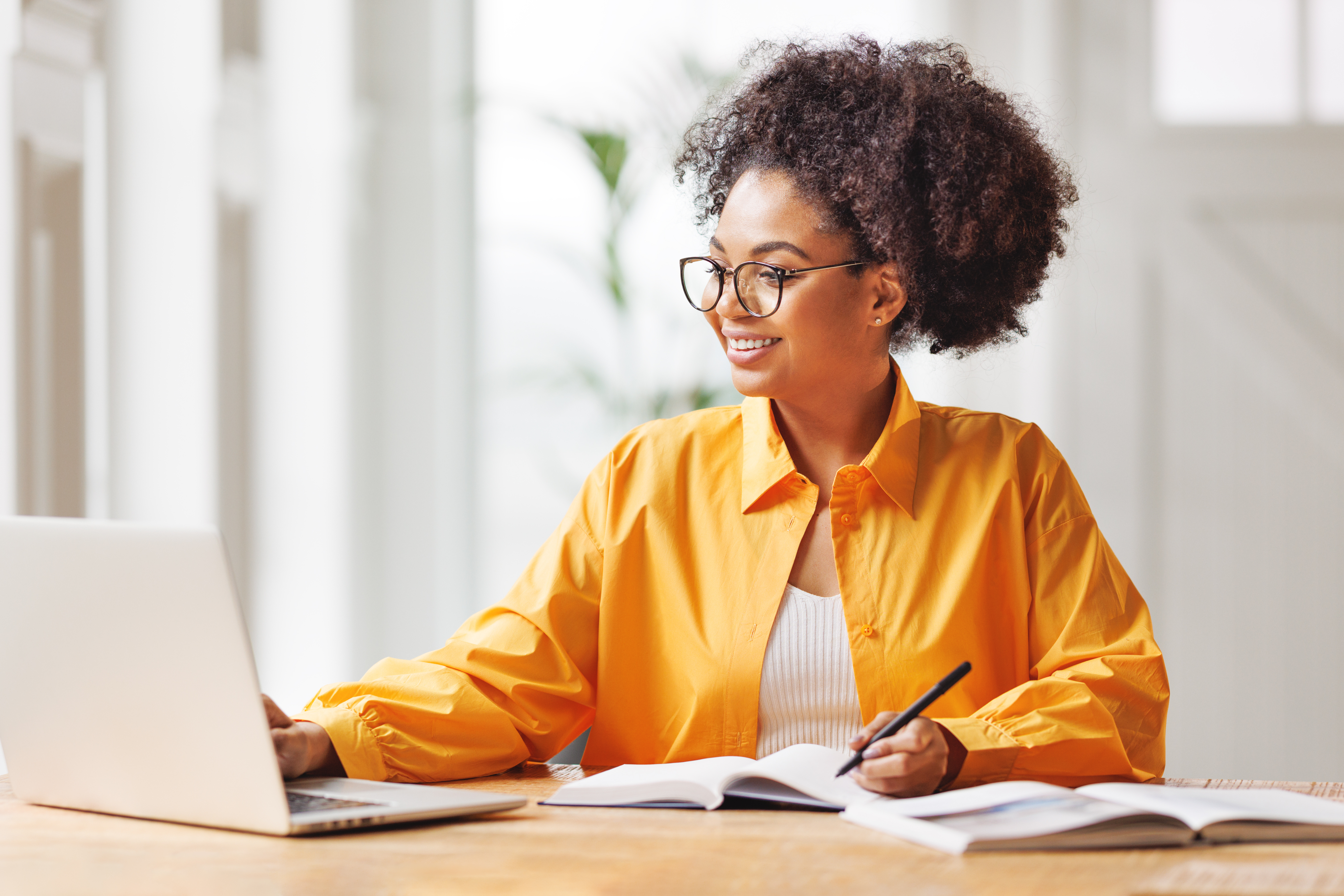 woman smiling looking at laptop while working remotely
