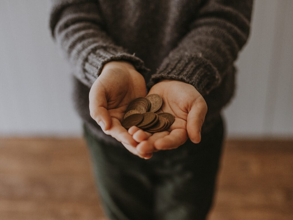 person holding out their hands with coins