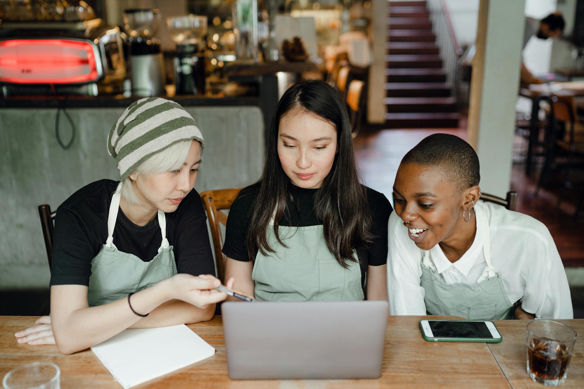 happy waitresses watching tutorials on laptop for fasta loan