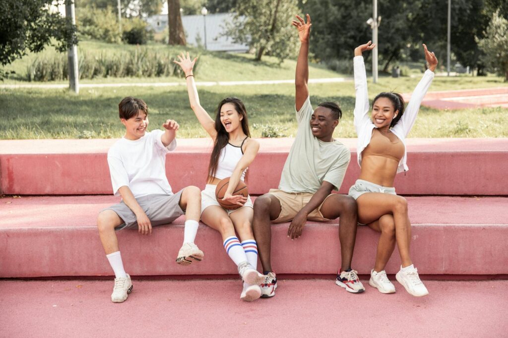 delighted friends raising arms happily on bench in park for financial future