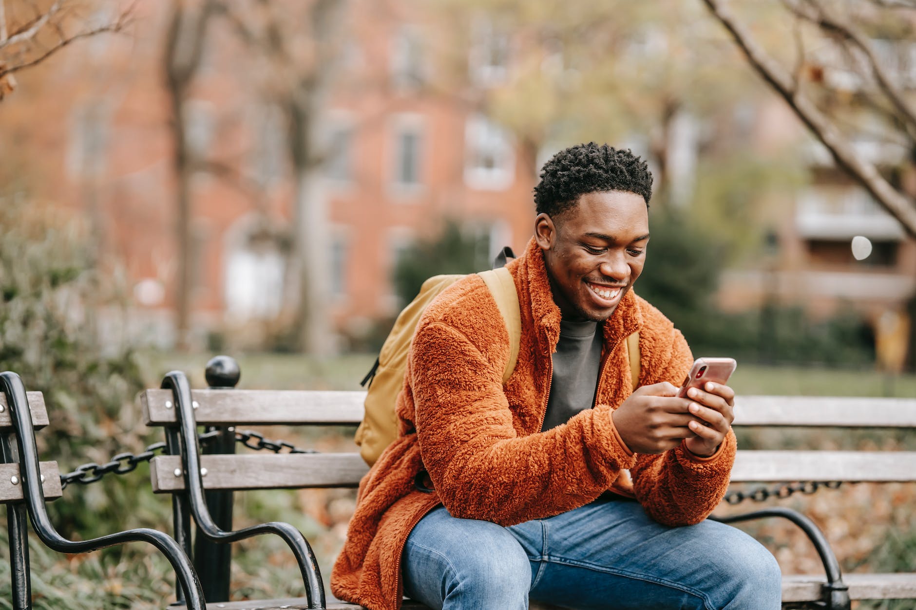smiling man looking at mobile phone screen
