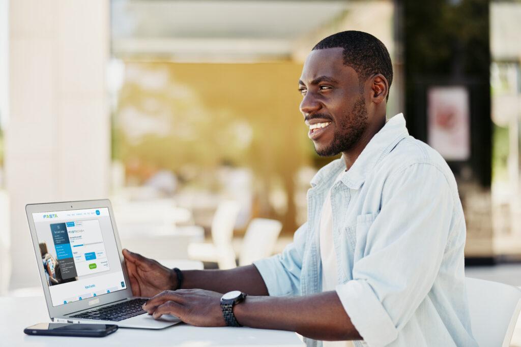 man using a laptop with fasta loan website on screen