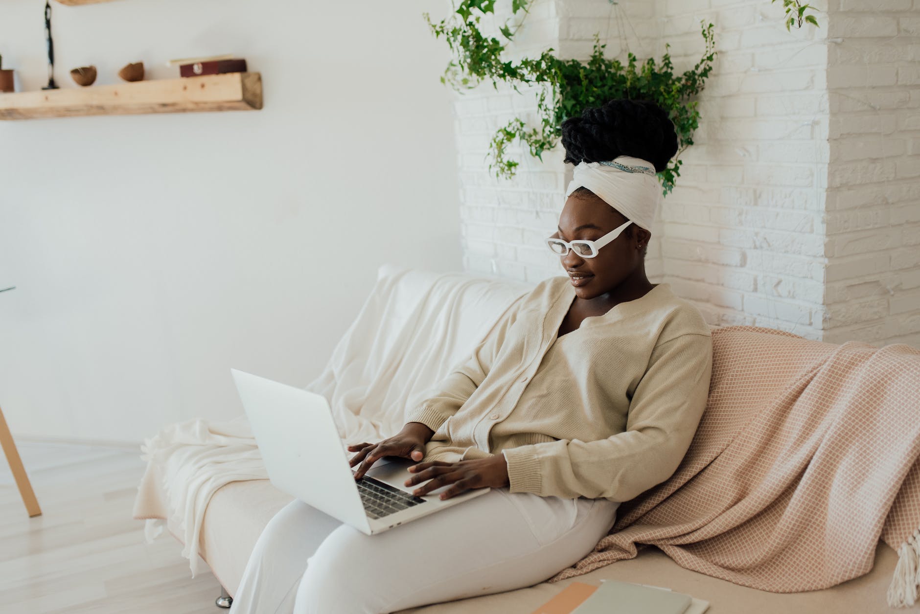 a happy woman using a laptop while sitting on a couch