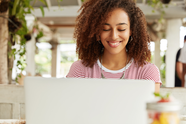 smiling woman looking at laptop screen for understanding credit score