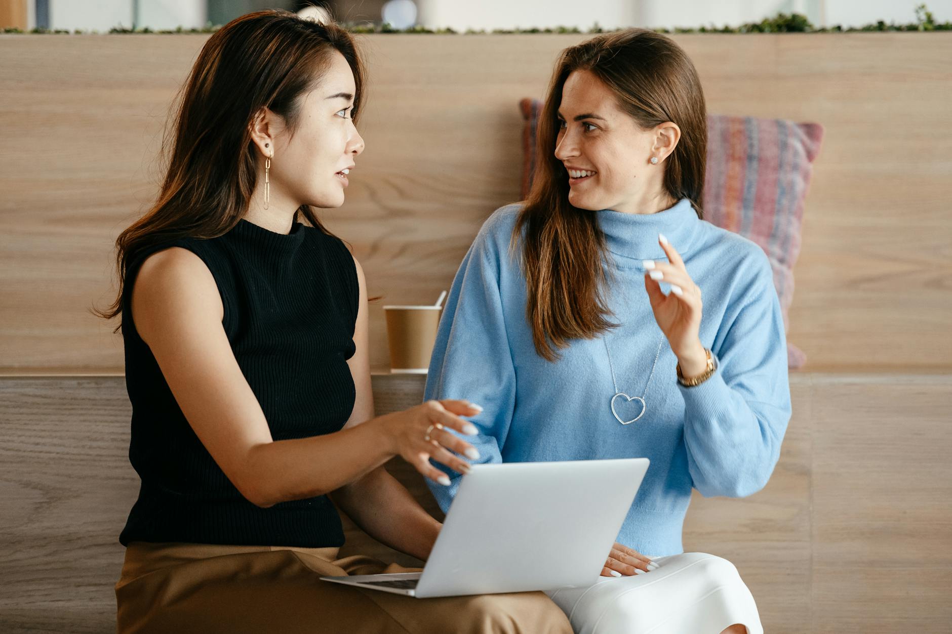 businesswomen with laptop talking about building credit with personal loans