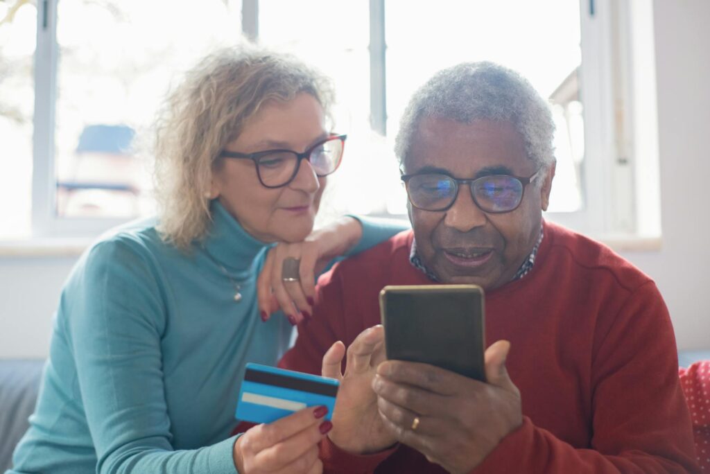 an elderly couple shopping online using credit card