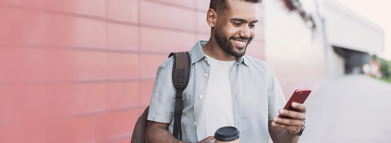 Smiling man looking at his mobile device.