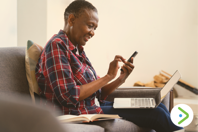 Lady smiling and looking at her phone.